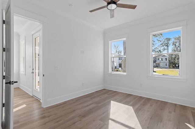 unfurnished room featuring plenty of natural light, light hardwood / wood-style floors, crown molding, and ceiling fan