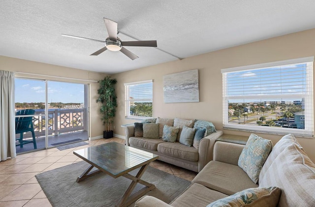 living room with a textured ceiling, ceiling fan, and light tile patterned flooring