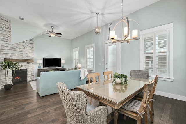 dining room with a fireplace, lofted ceiling, ceiling fan with notable chandelier, and dark wood-type flooring