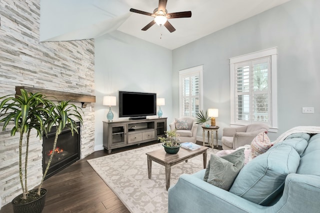 living room with a fireplace, lofted ceiling, ceiling fan, and dark wood-type flooring