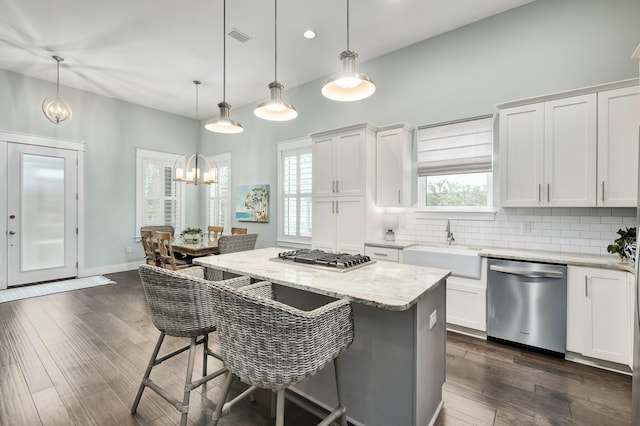 kitchen featuring plenty of natural light, white cabinets, hanging light fixtures, and appliances with stainless steel finishes