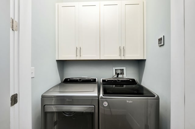 laundry area with washer and clothes dryer and cabinets