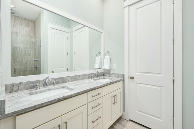 bathroom featuring wood-type flooring, vanity, and walk in shower