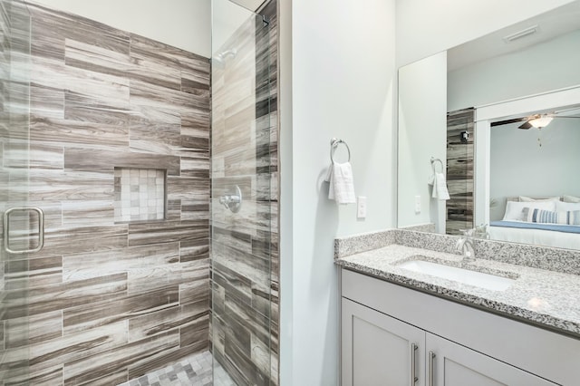 bathroom featuring ceiling fan, vanity, and a shower with shower door