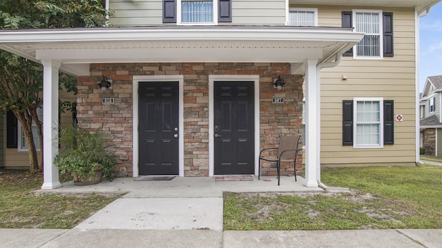 doorway to property featuring a lawn