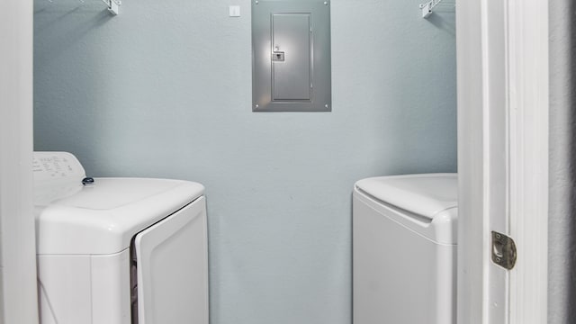 clothes washing area featuring separate washer and dryer and electric panel