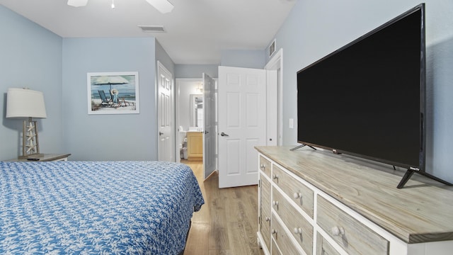 bedroom featuring ceiling fan, ensuite bath, and light hardwood / wood-style flooring