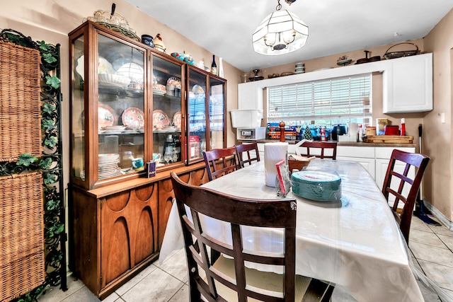 tiled dining space featuring a notable chandelier