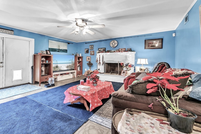 living room with carpet flooring, ceiling fan, and a brick fireplace