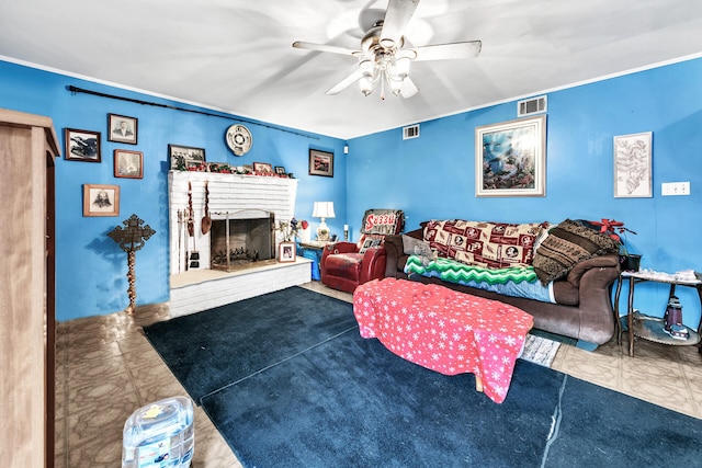 living room featuring ceiling fan, crown molding, and a fireplace