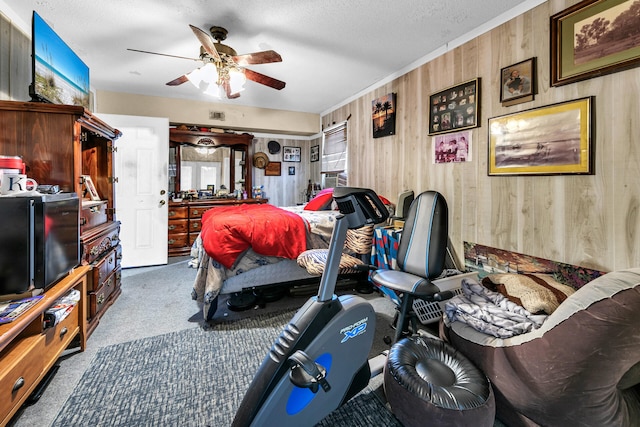 bedroom with ceiling fan, carpet floors, a textured ceiling, and wooden walls