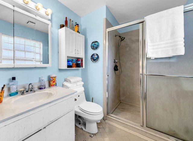 bathroom featuring vanity, toilet, and walk in shower