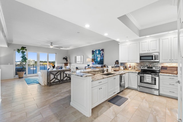 kitchen with kitchen peninsula, white cabinetry, sink, and stainless steel appliances