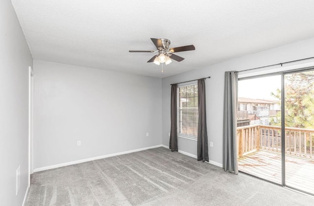 spare room with a textured ceiling, light colored carpet, and ceiling fan