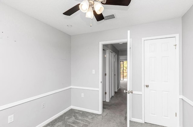 carpeted empty room featuring ceiling fan and a textured ceiling