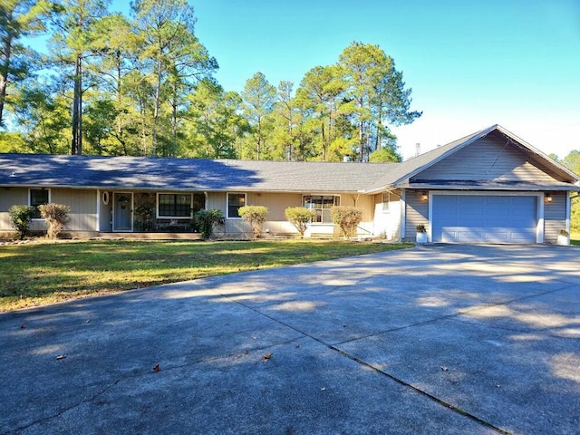 single story home featuring driveway, a garage, and a front lawn