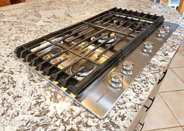 interior details featuring stone counters and stainless steel gas cooktop