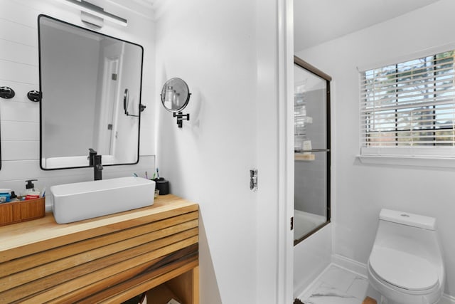 full bathroom with vanity, toilet, and bath / shower combo with glass door