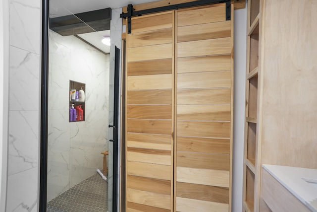 interior space with a barn door and a shower with shower door