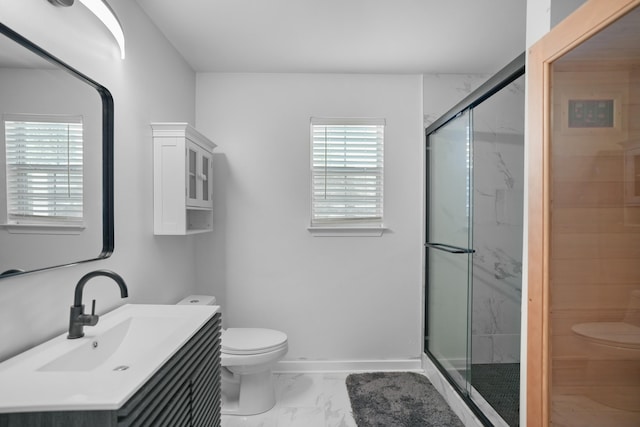 bathroom featuring a shower with door, vanity, and toilet