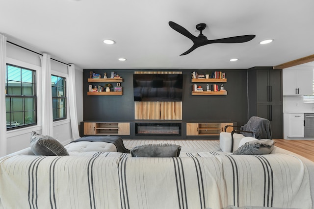 cinema room featuring hardwood / wood-style flooring and ceiling fan