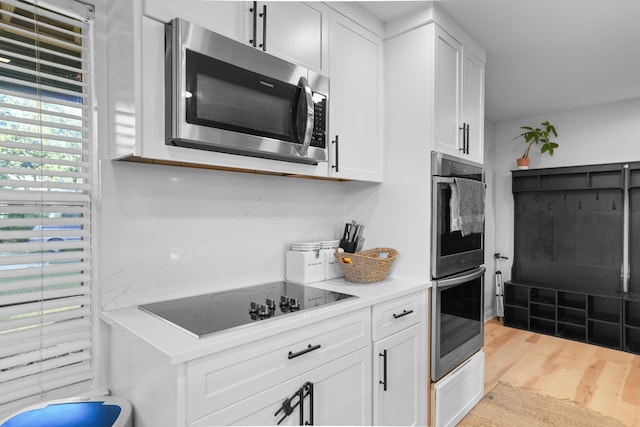 kitchen featuring white cabinets, stainless steel appliances, and light hardwood / wood-style floors