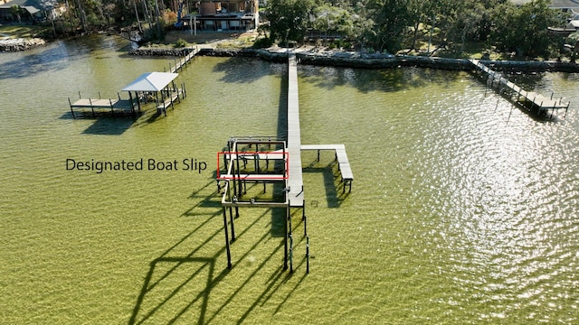 view of dock with a yard and a water view