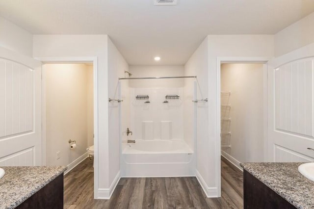 full bathroom with hardwood / wood-style floors, vanity, toilet, and tub / shower combination