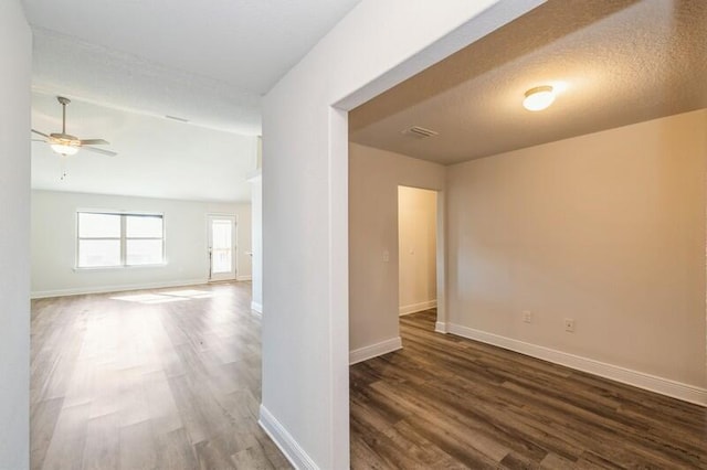 unfurnished room with hardwood / wood-style flooring, ceiling fan, and a textured ceiling