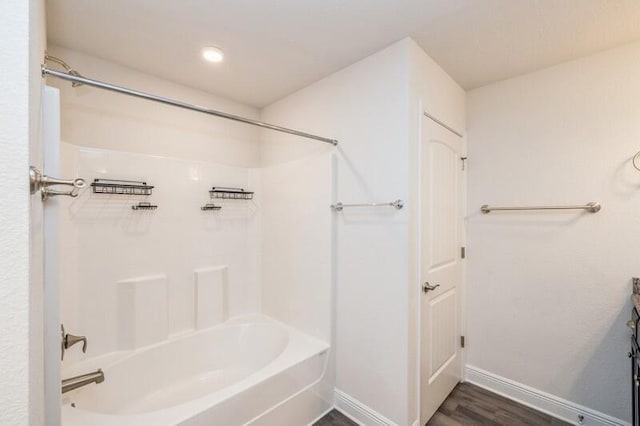 bathroom featuring washtub / shower combination and hardwood / wood-style flooring