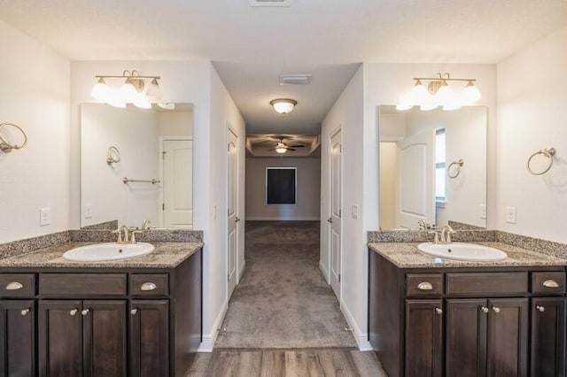 bathroom with hardwood / wood-style floors, vanity, and ceiling fan