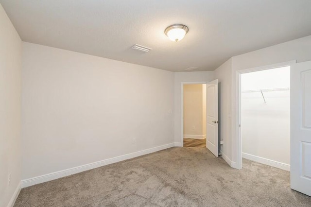 unfurnished bedroom featuring light carpet and a closet