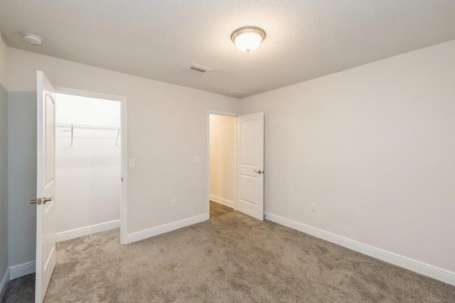 unfurnished bedroom with light colored carpet and a closet