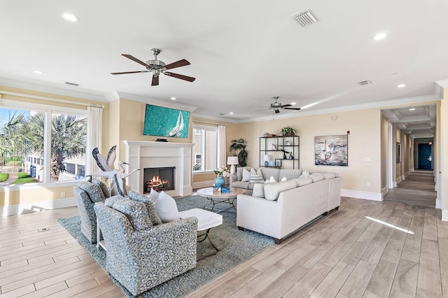 living room with ceiling fan, a healthy amount of sunlight, and crown molding