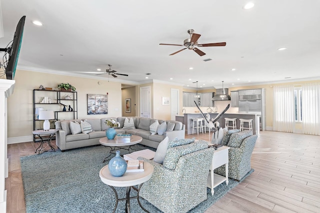 living room featuring ceiling fan, light hardwood / wood-style flooring, and ornamental molding