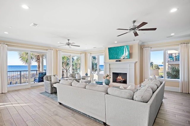 living room with a water view, plenty of natural light, and crown molding