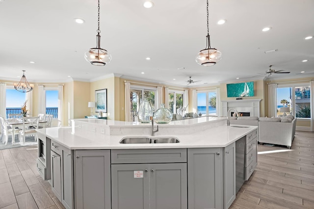 kitchen with hanging light fixtures, ornamental molding, gray cabinets, and a large island