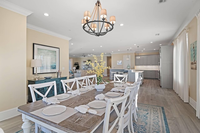 dining space featuring ornamental molding, ceiling fan with notable chandelier, and light hardwood / wood-style flooring