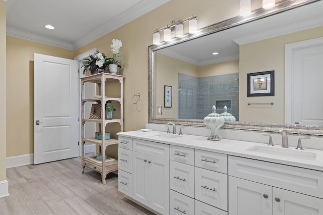 bathroom featuring wood-type flooring, tiled shower, vanity, and ornamental molding