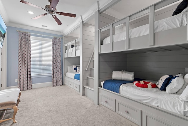 carpeted bedroom with ceiling fan and ornamental molding