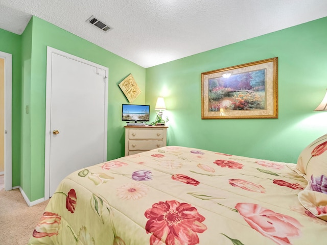 bedroom featuring light colored carpet and a textured ceiling