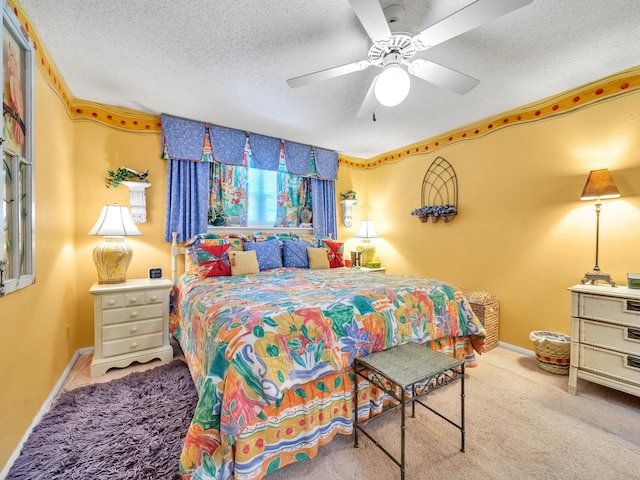 bedroom with ceiling fan, light colored carpet, and a textured ceiling