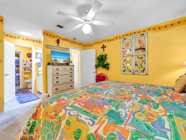 carpeted bedroom with ceiling fan and ensuite bath