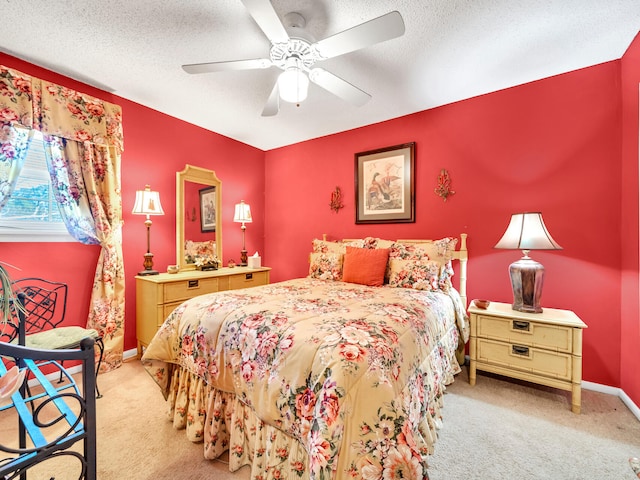 carpeted bedroom featuring ceiling fan and a textured ceiling