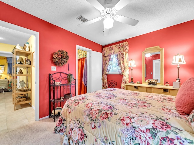 carpeted bedroom featuring ceiling fan and a textured ceiling