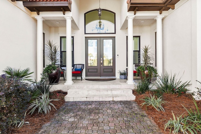 view of exterior entry with covered porch and french doors