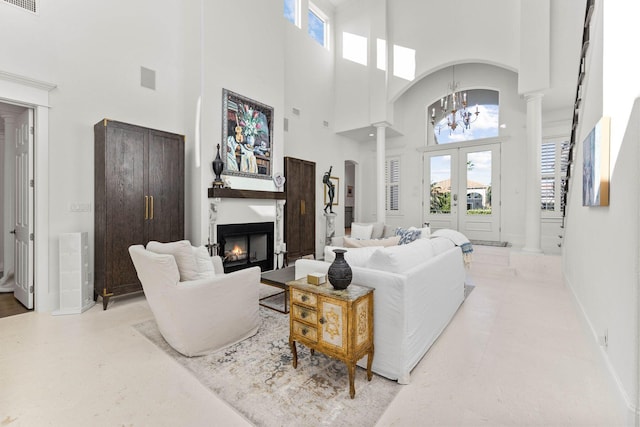 living room with a notable chandelier, a towering ceiling, and french doors