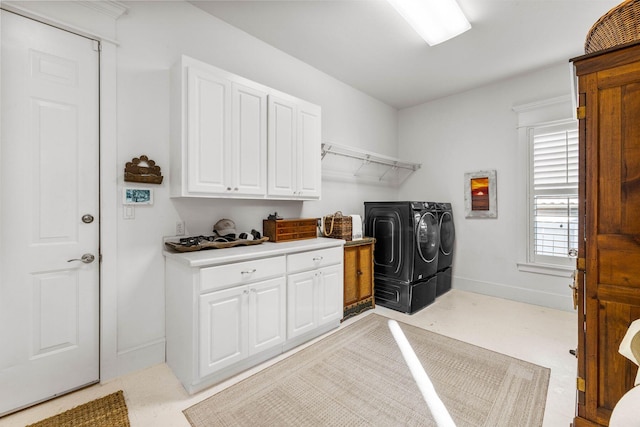 clothes washing area featuring cabinets and washing machine and dryer