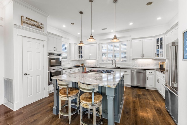 kitchen with white cabinets, a kitchen island, and a healthy amount of sunlight