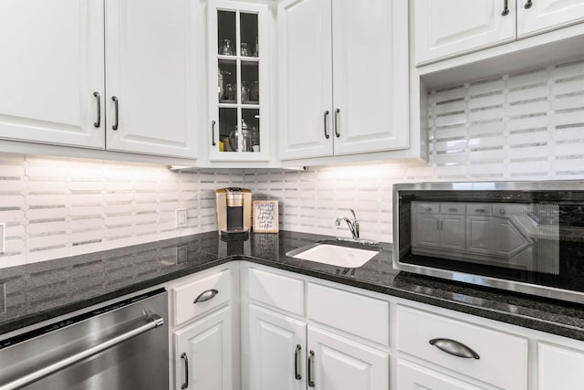 kitchen with backsplash, sink, white cabinets, and appliances with stainless steel finishes